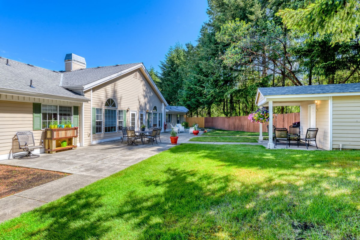 A beautiful backyard with a spacious patio area, well-maintained lawn, and cozy gazebo.