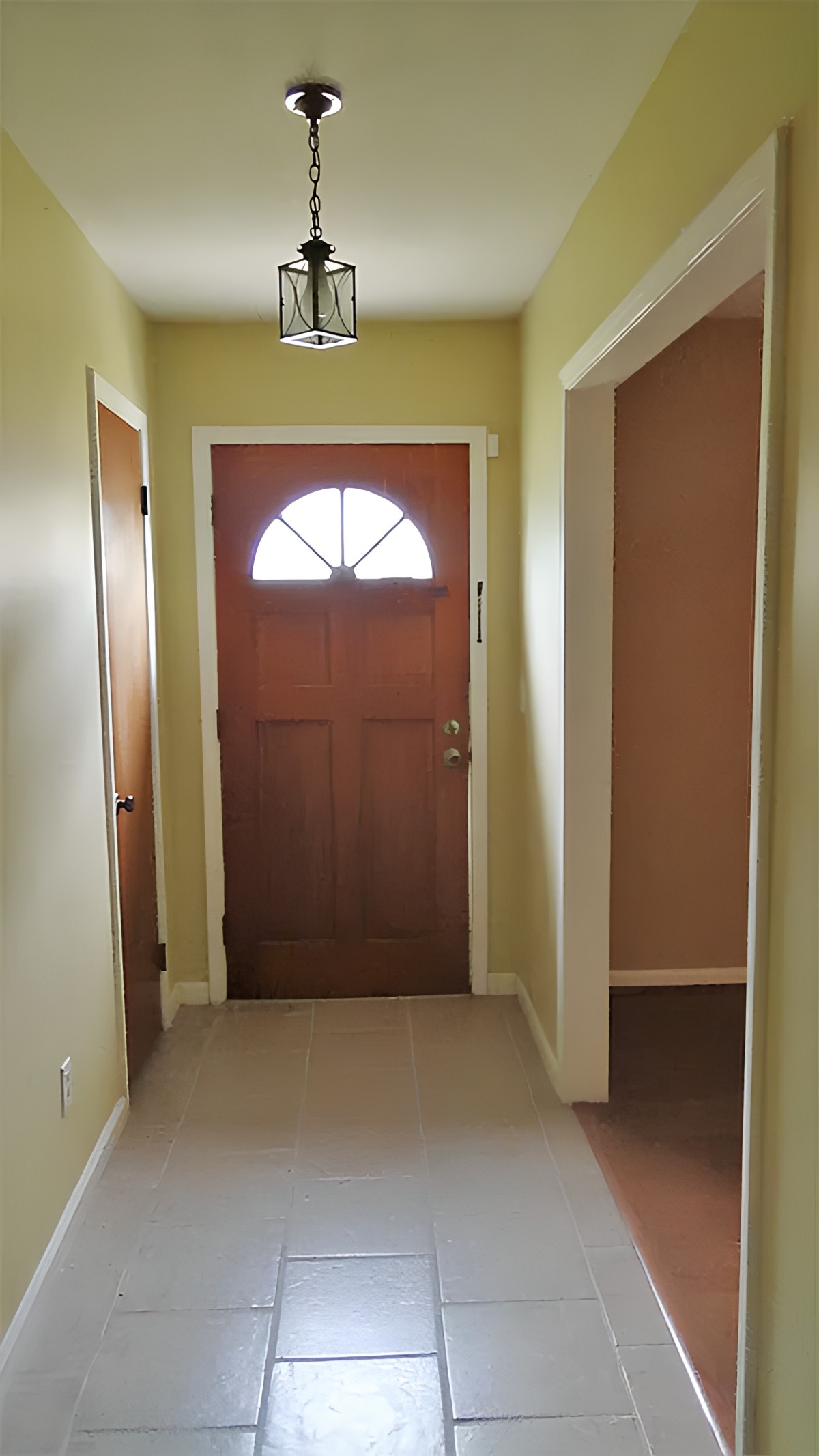 A hallway with an entrance door in a home.
