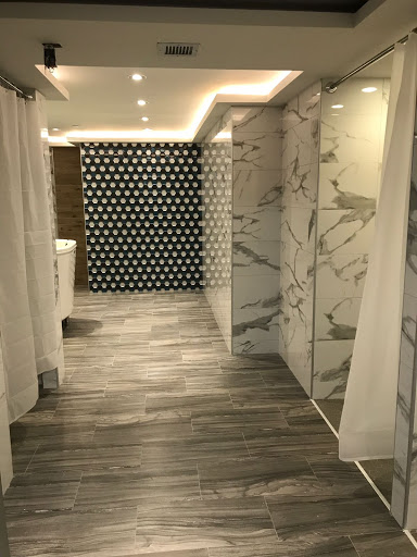 A stylish and modern bathroom featuring marble walls, wooden flooring, and unique patterned tiles.