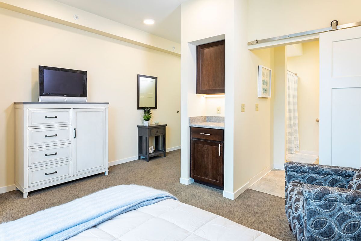 A modern bedroom with stylish furniture and neutral colors.