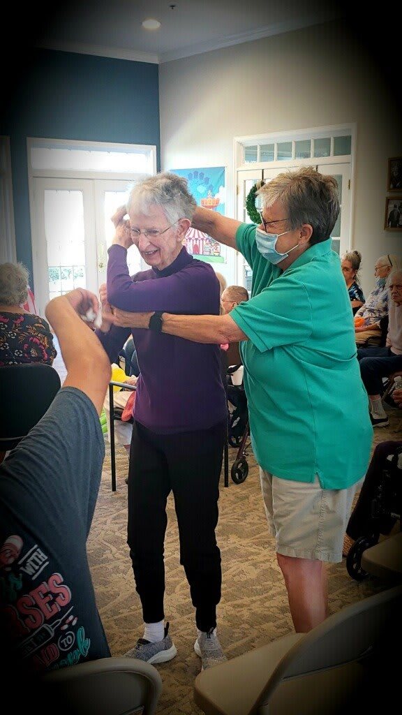 Two seniors enjoying a dance together in a community setting.