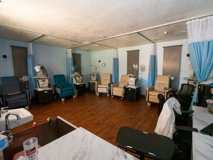 A healthcare facility room equipped with dialysis chairs and medical equipment.