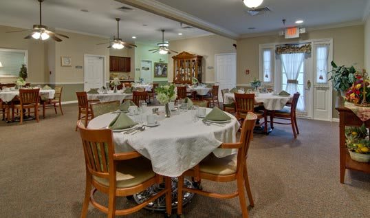 A well-set dining room with neatly arranged tables and chairs.