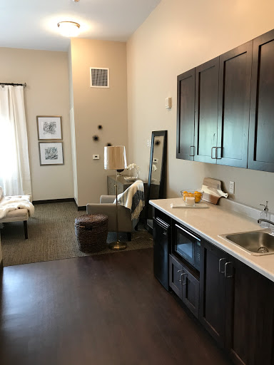 A cozy living space featuring a kitchenette, comfortable seating, and minimalist decor.