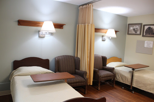 A cozy hotel room featuring two beds, comfortable seating, and warm lighting.