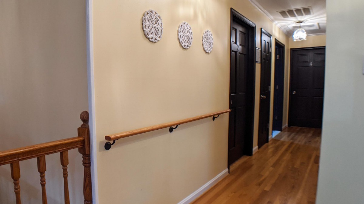 A hallway with a wooden handrail and decorative wall plates.