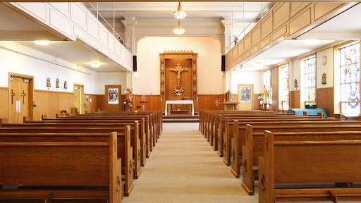 A serene view of a church interior featuring wooden pews and an altar.