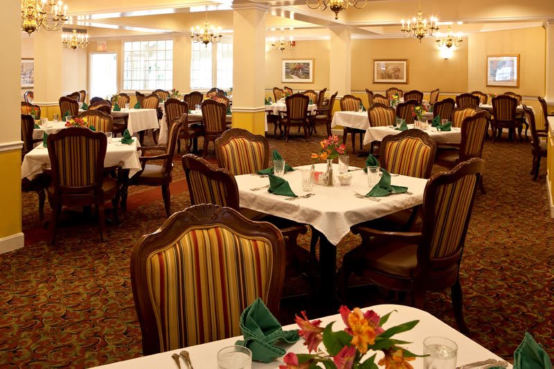 An elegantly set dining room with neatly arranged tables and chairs.
