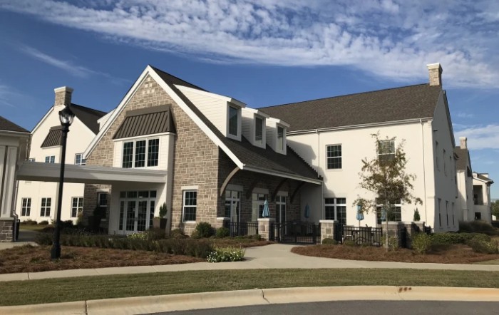 A residential building with a stone facade and well-maintained landscaping.