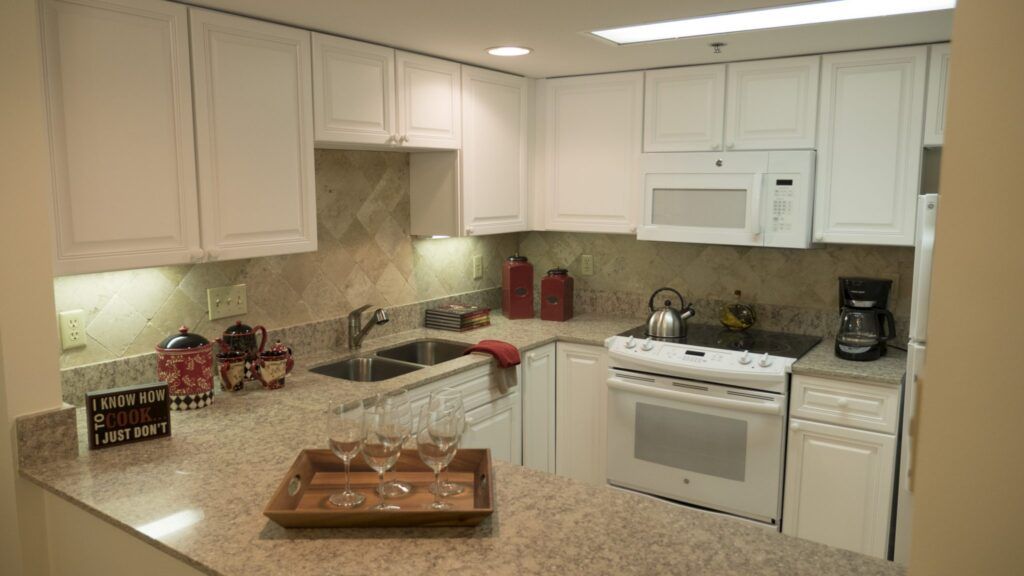 A modern kitchen with white cabinets and stylish decor.