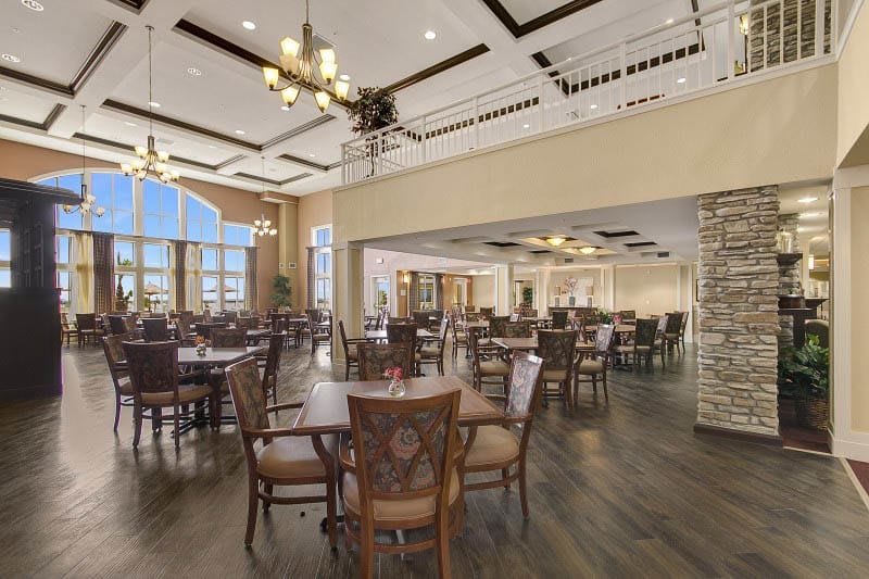 A spacious dining area with elegant chandeliers and wooden furnishings.