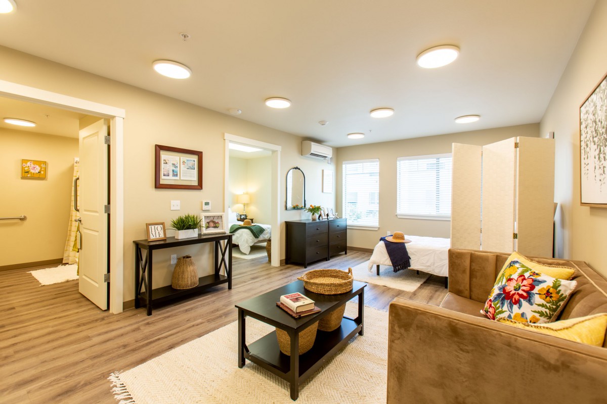 A modern living room with stylish decor, featuring a comfortable sofa, coffee table, and bright lighting.
