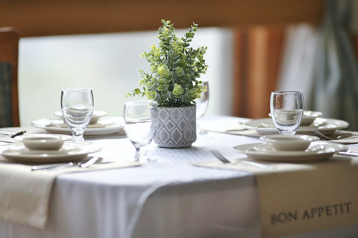 A beautifully arranged table featuring a small potted plant centerpiece and elegant glassware, perfect for dining.
