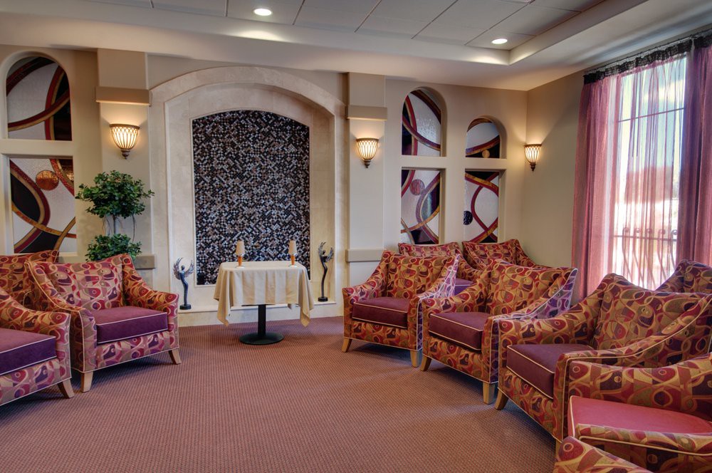 A cozy lounge area with upholstered chairs and a decorative stone wall feature.