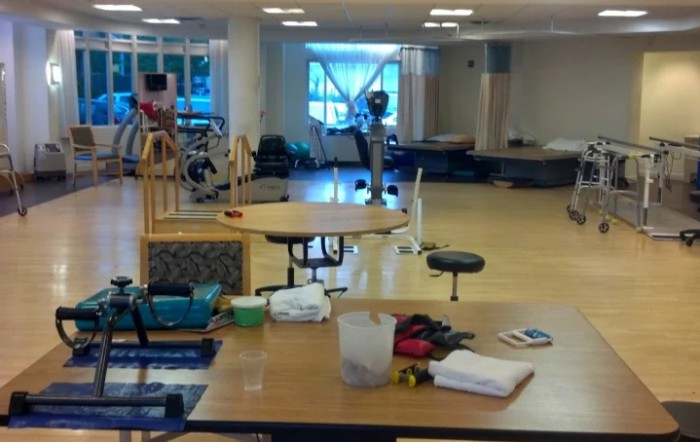 A spacious physical therapy room equipped with rehabilitation tools and exercise equipment.