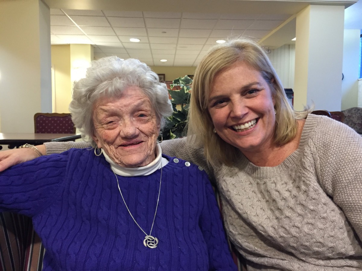 Two women smiling together indoors.