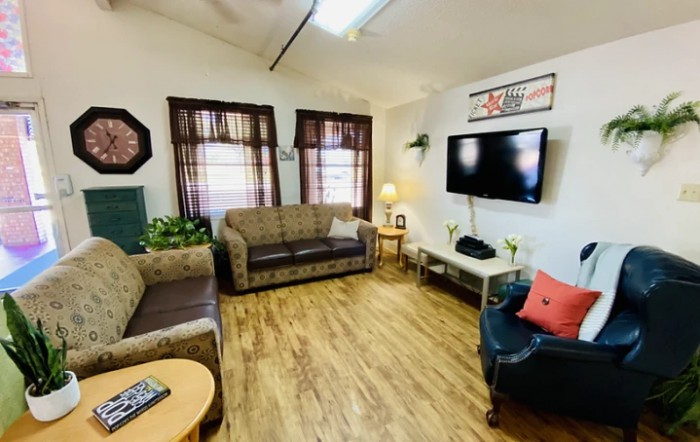 Cozy living room with sofas, a TV, and wooden flooring.