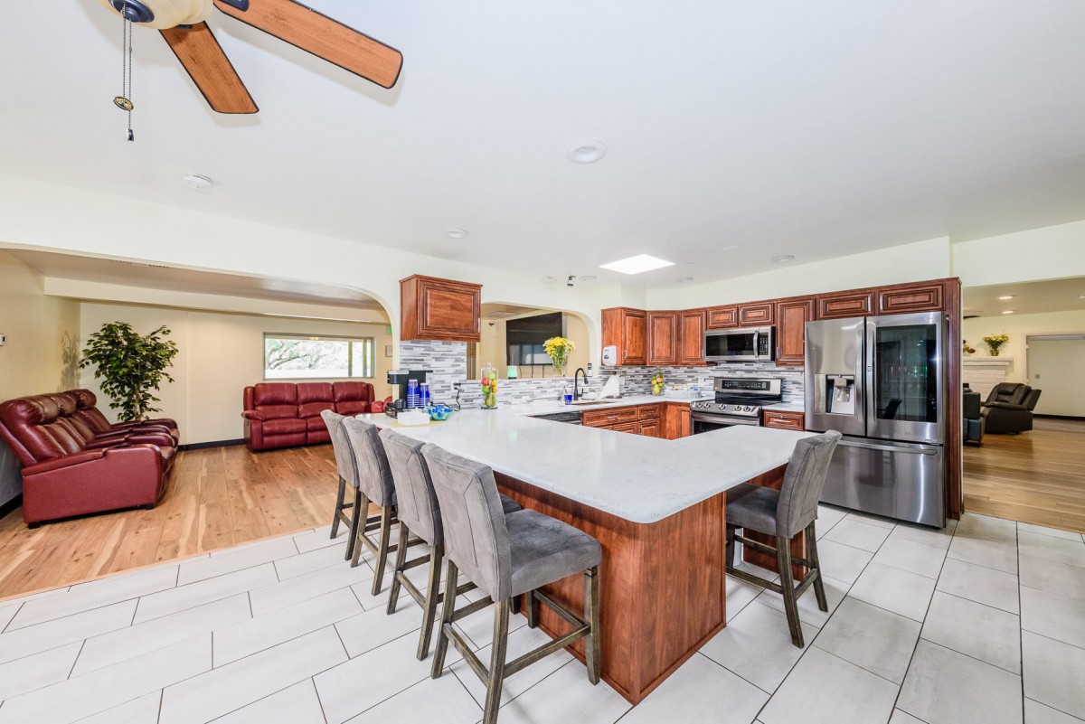 A spacious modern kitchen featuring a large island with bar stools and stainless steel appliances.