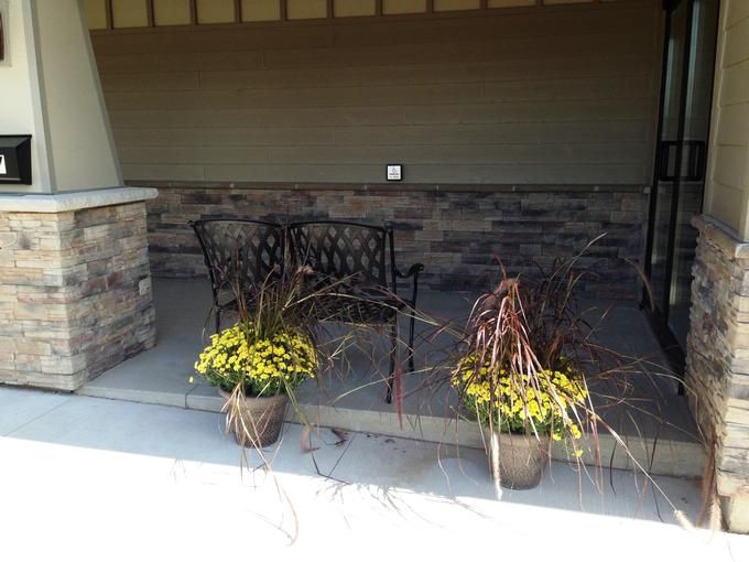A cozy patio setting with a bench and potted plants.