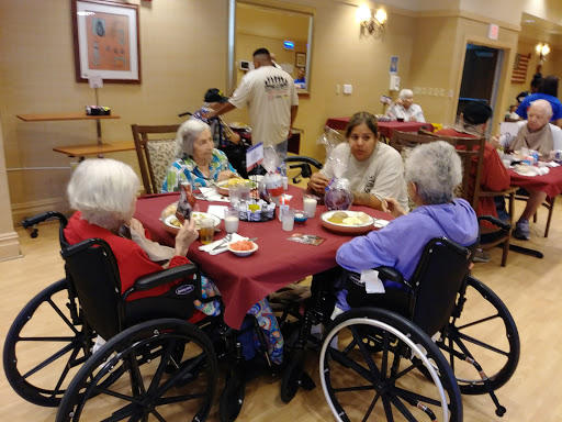 A group of elderly residents enjoying a meal together in a care facility.