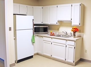A modern kitchen with white cabinets and appliances.