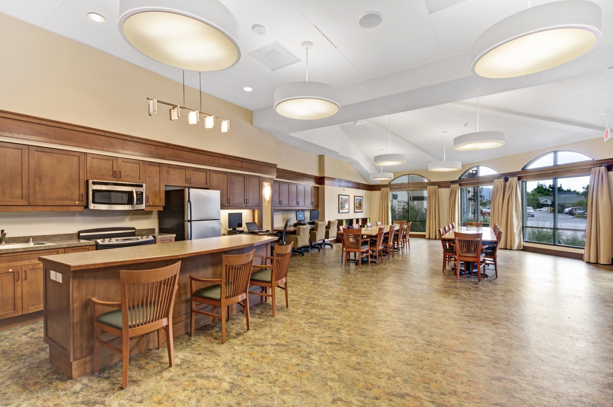 A modern kitchen and dining area with wooden furniture and appliances.