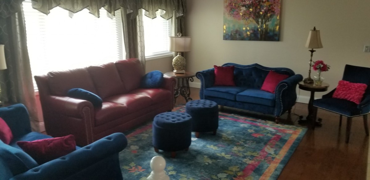 A cozy living room with colorful furniture and a vibrant area rug.