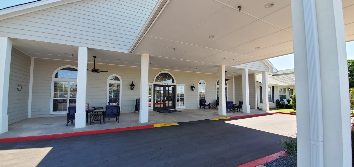 Entrance of a building with columns and a covered patio area.