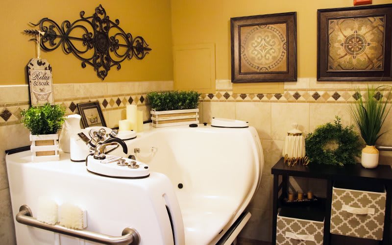 A cozy bathroom with a spa tub, warm yellow walls, and decorative wall art.