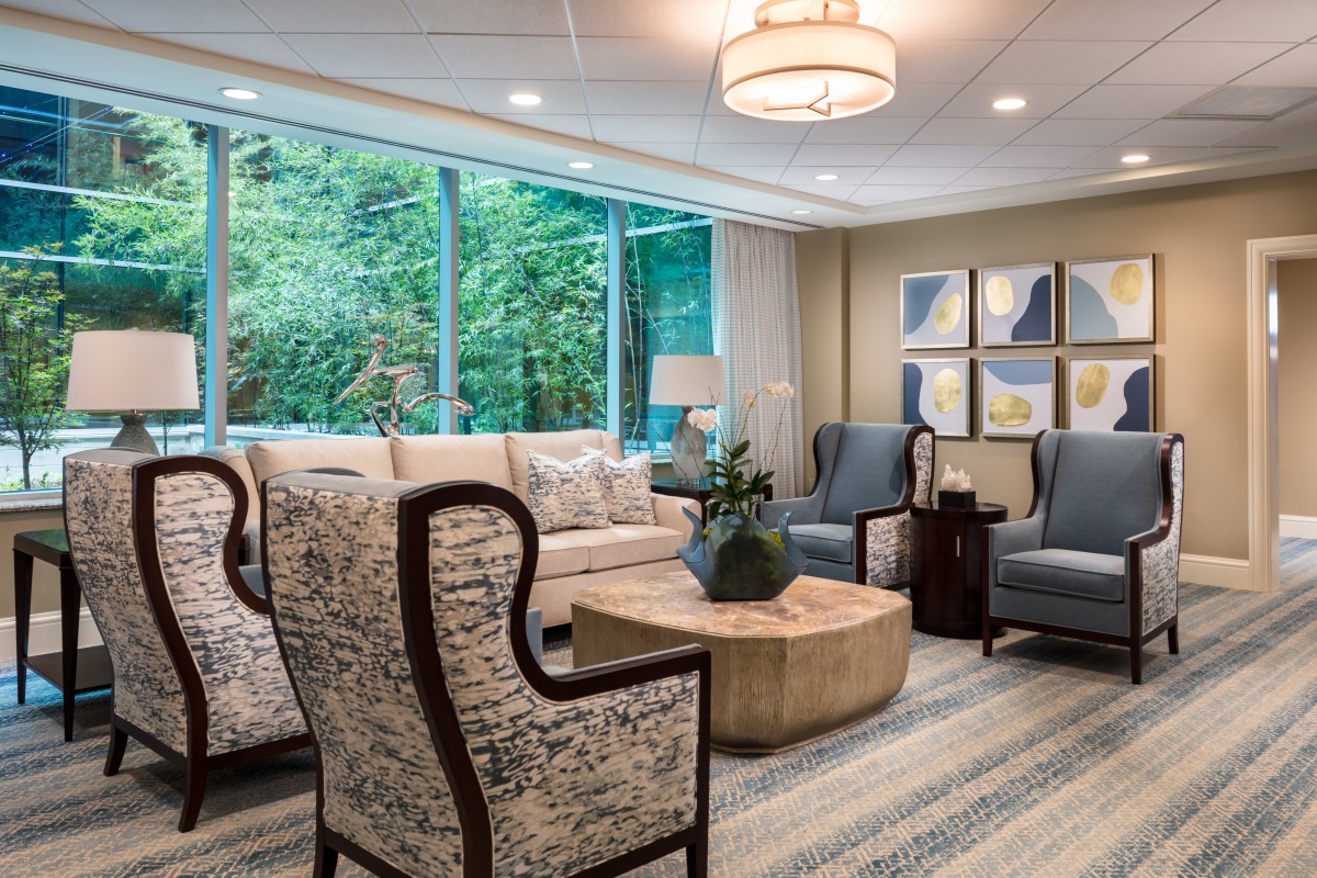 A modern living room with comfortable seating, a large window, and elegant decor.