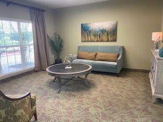 A cozy living room with a sofa, coffee table, and artwork on the wall.