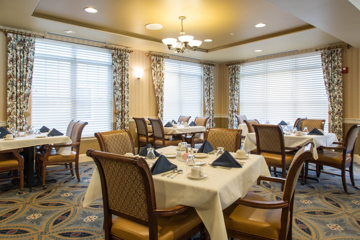 An elegant dining room with neatly set tables and comfortable chairs.