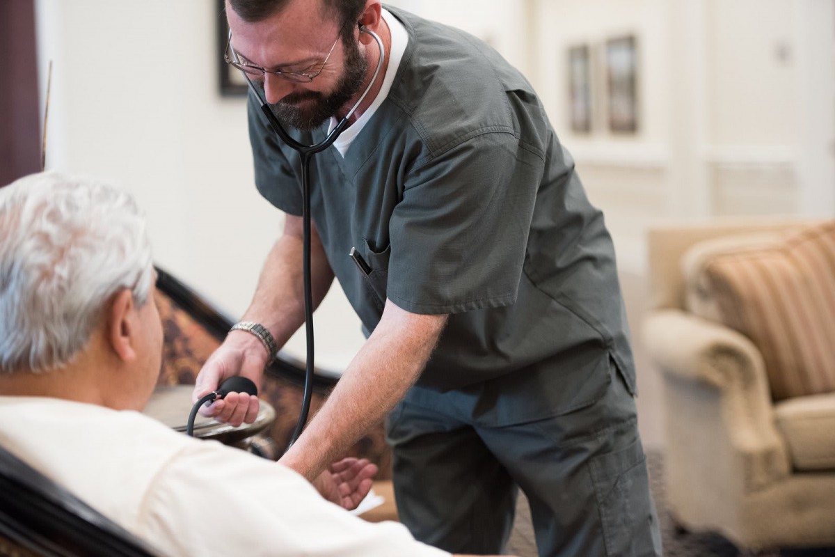 A doctor examining a patient with a stethoscope in a healthcare setting.