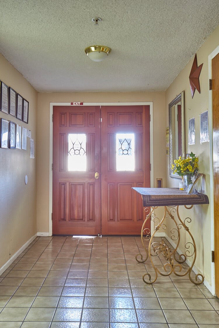 A welcoming entryway featuring wooden double doors and tasteful decor.