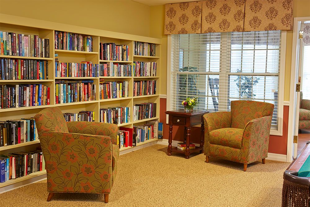 A cozy reading corner with bookshelves and comfortable chairs by the window.