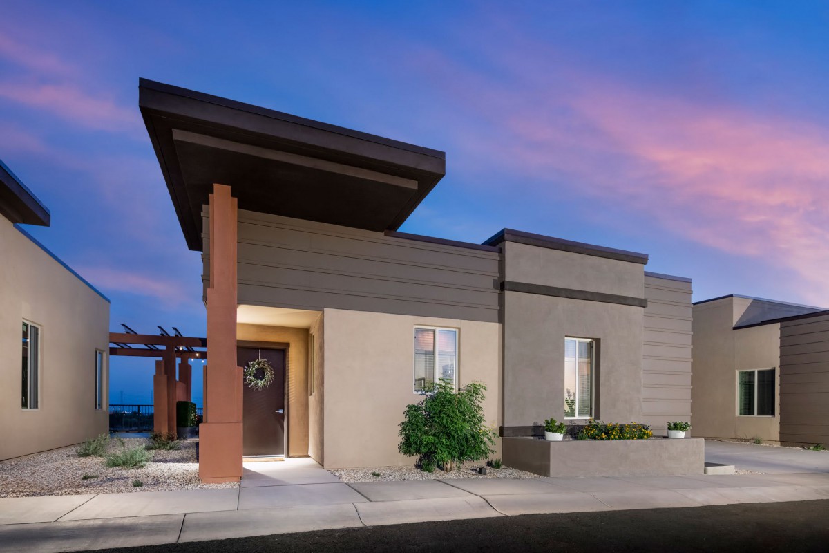 A modern house exterior at dusk with a beautifully colored sky.