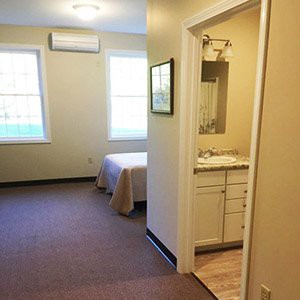 A minimalist bedroom with a view into an adjoining bathroom.