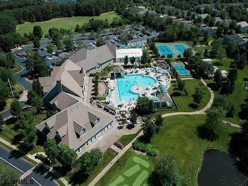 Aerial view of a resort featuring swimming pools and lush green landscapes.