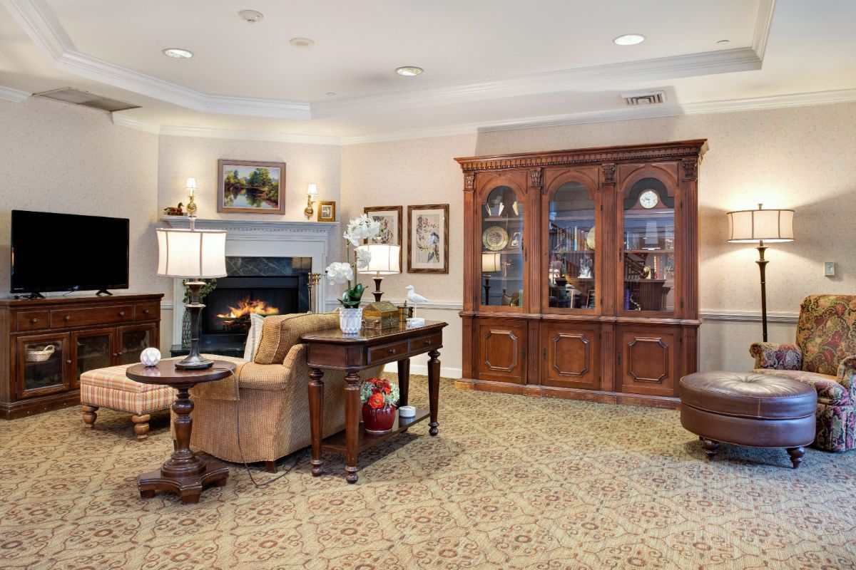 A cozy living room featuring a fireplace, wooden furniture, and elegant decor.