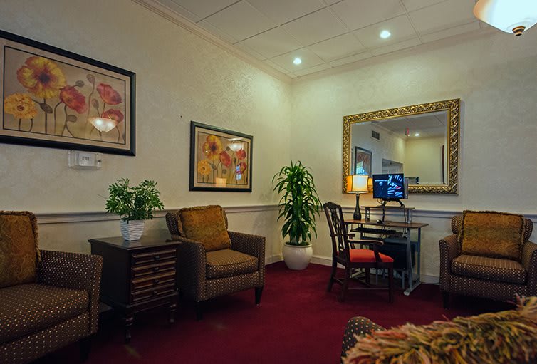 A cozy living room with comfortable seating, decorative plants, and framed artwork on the walls.
