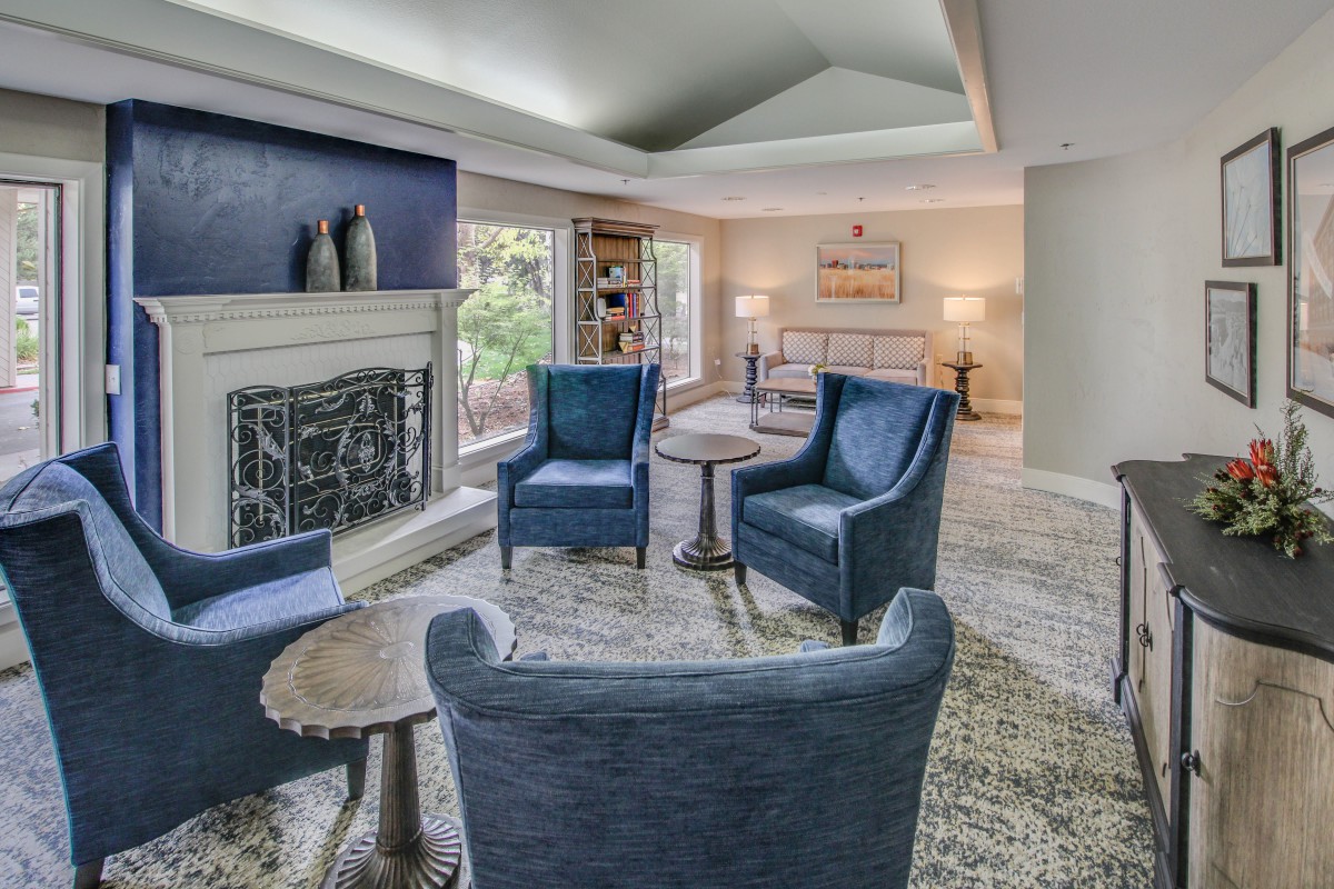 A cozy living room with blue chairs, a fireplace, and modern decor.