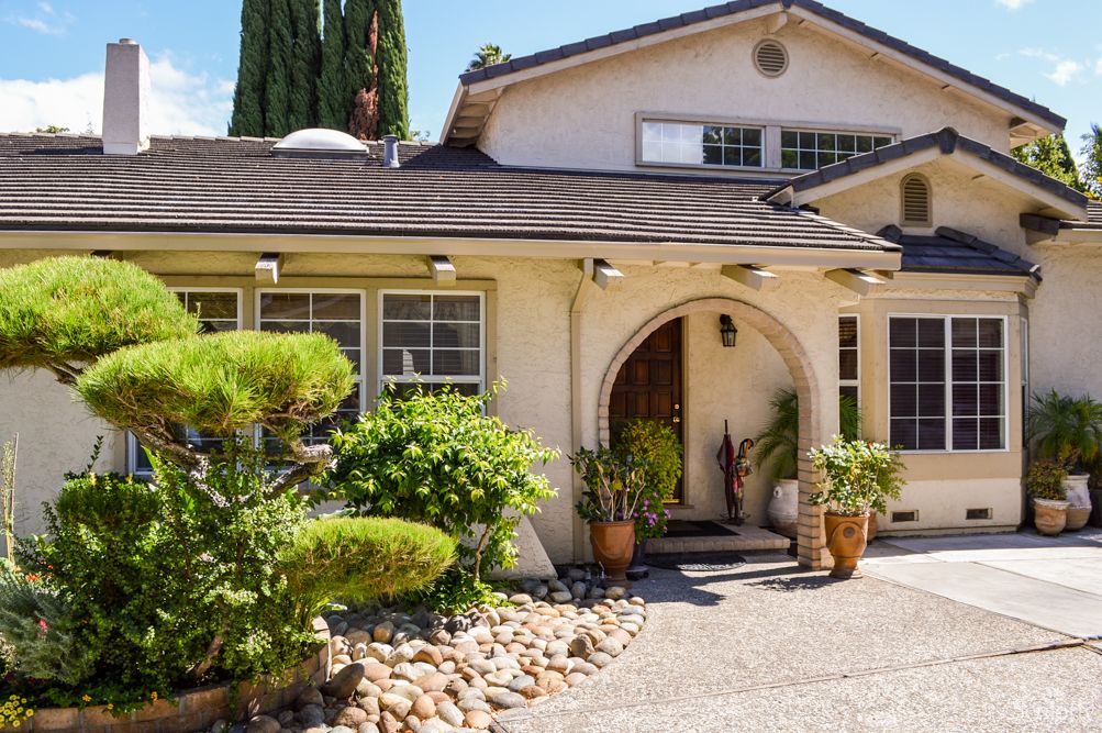 A charming residential house with a well-maintained garden and pathway.