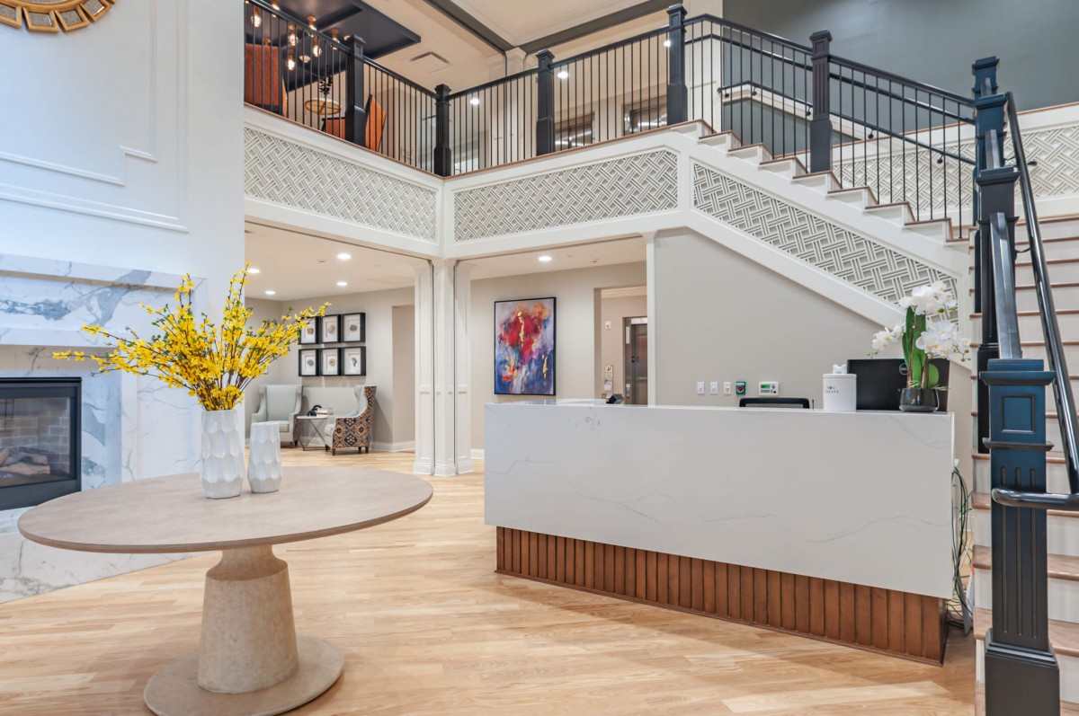 A modern reception area featuring a staircase, contemporary artwork, and elegant decor.