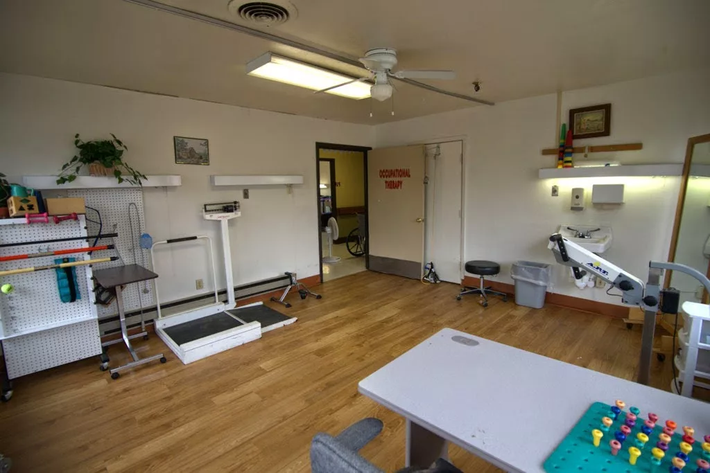 A clean and organized medical examination room with equipment and a scale.