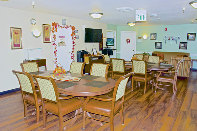 A cozy dining area with neatly arranged tables and chairs, decorated with seasonal ornaments.