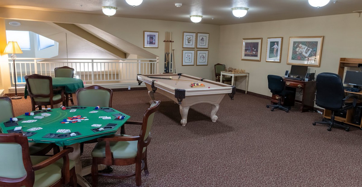 A cozy game room featuring a billiard table and seating area.