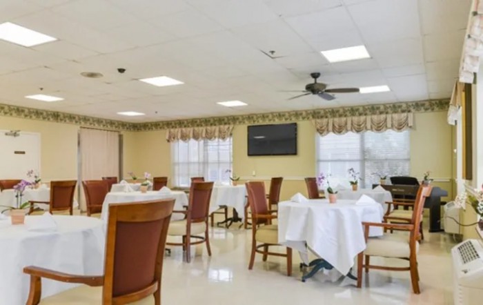 An empty dining room with neatly arranged tables and chairs.