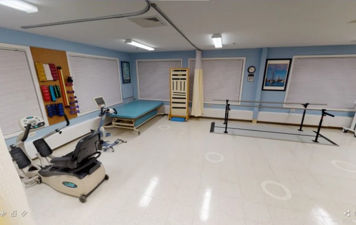 A spacious physical therapy room equipped with various rehabilitation tools and exercise equipment.