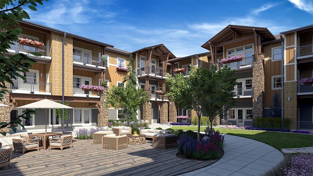 A modern apartment complex with a landscaped courtyard and outdoor seating area.