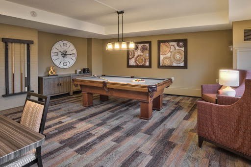 A stylish game room featuring a pool table, modern decor, and inviting seating.